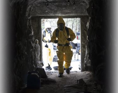 EOD Soldier enters bunker wearing protective gear.