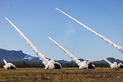 High Mobility Artillery Rocket Systems from the Australian Army, the United States Army and the Singapore Army fire a salvo of rockets during a combined joint live fire exercise in Queensland, Australia during Exercise Talisman Sabre 25. The exercise is designed to enhance combat readiness and interoperability with allies and partners. (Photo courtesy of ADF CPL Michael Rogers) (Photo Credit: Staff Sgt. Kylee Marshall).